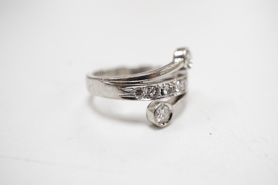 A recent 14k white metal and diamond ring, the ring head designed as three bands, central row of seven graduated diamonds, with two outer collet set diamonds, size G/H.